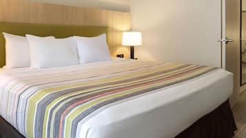 Escritorio, cortinas blackout y tabla de planchar con plancha