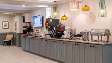A kitchen area with a coffee machine, a grill, and a display screen.