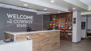 A reception desk with a 'Welcome to the Cowboy State' sign, a counter with a water dispenser, and a store with various items.