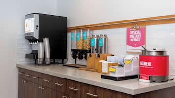 Un área de cocina con cafetera, dispensadores y un cartel para necesidades dietéticas especiales.
