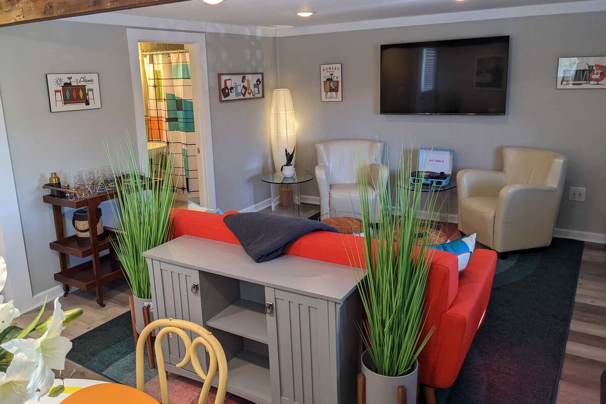 A modern living room with a sofa, a TV, a small table, and a cabinet.