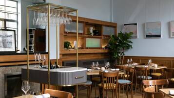 Ein Restaurantinneres mit Holzkunst, einer zentralen Bar und Kunstwerken an den Wänden.