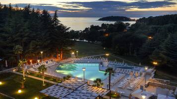 Una piscina al aire libre de temporada, sombrillas, tumbonas