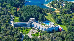 Eine Vogelperspektive eines großen Hotels mit mehreren Gebäuden, einem Schwimmbad und einem Yachthafen mit Booten.