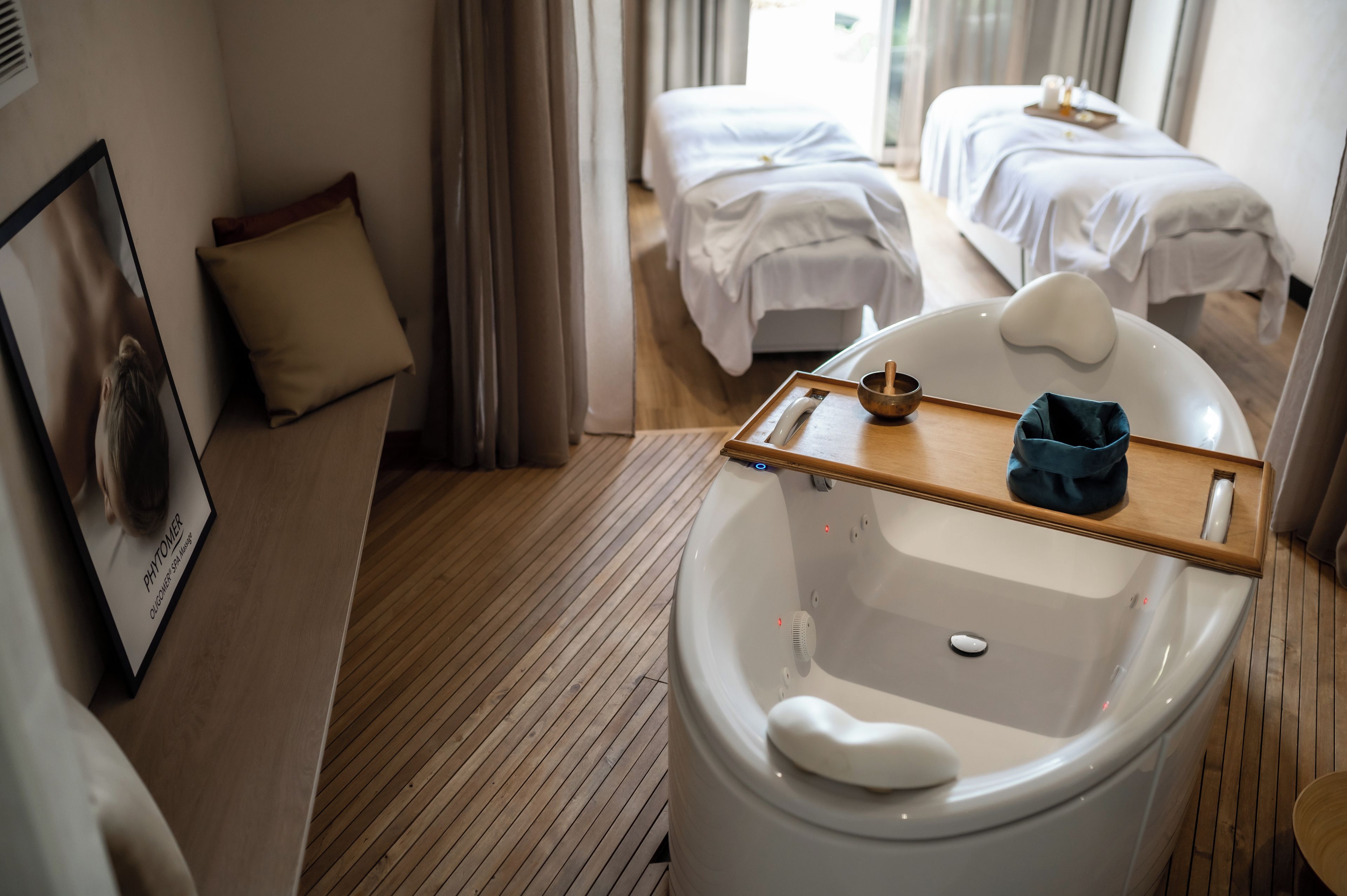 A hotel bathroom with a bathtub, a wooden tray, and a towel rack.