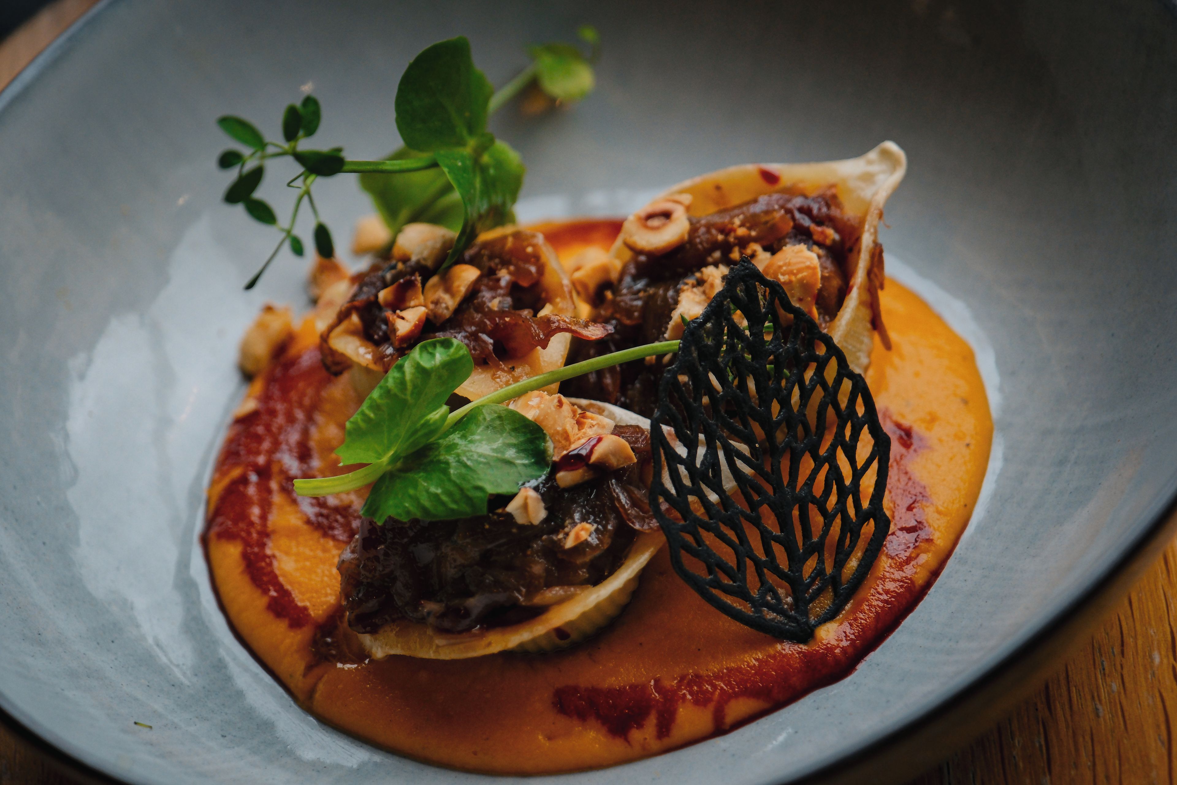A dish with a variety of ingredients, including greens, mushrooms, and a sauce.