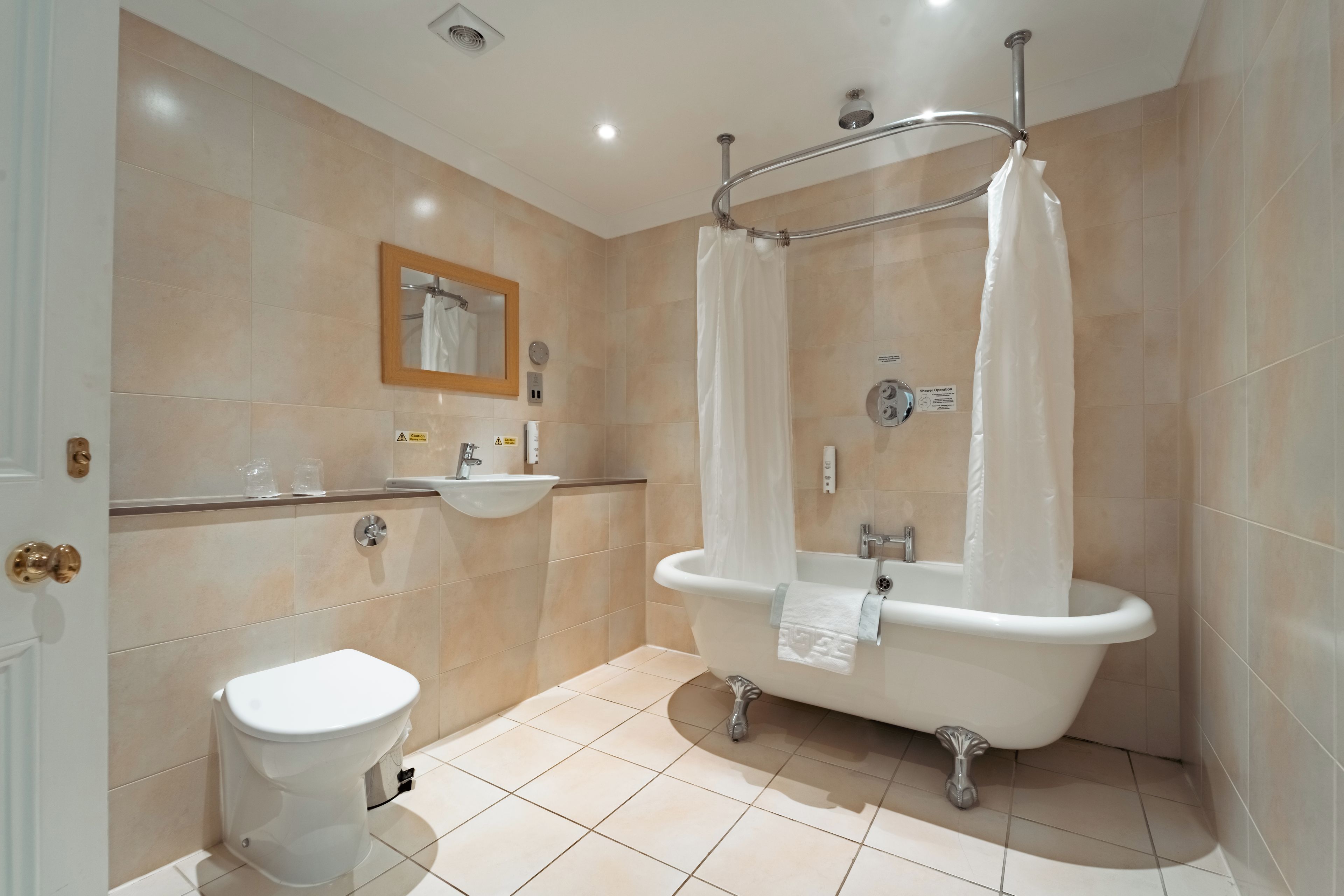 A modern bathroom with a toilet, sink, and bathtub.