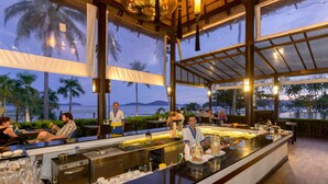 A bar area with a view of the ocean, equipped with a buffet and bar service. - The Vijitt Resort Phuket (Rawai)
