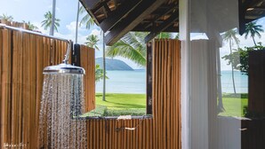 A wooden structure with a view of a beach and palm trees. - The Vijitt Resort Phuket (Rawai)