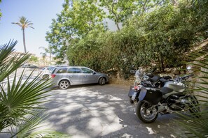Un estacionamiento con una motocicleta y un automóvil.