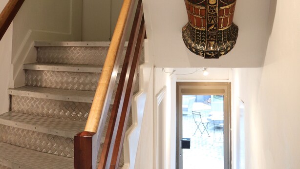 Un escalier avec une rampe en bois et une porte en bas.