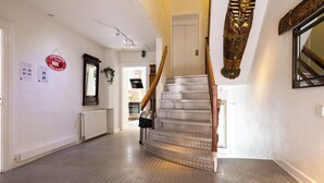 Un escalier dont les marches sont décorées d’un motif particulier, menant à une porte.