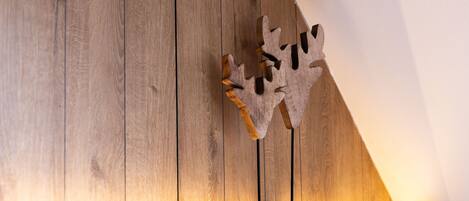 A wooden wall with a leaf-shaped decoration and a shelf.