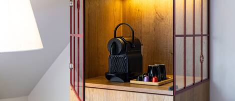 A compact kitchenette with a coffee machine, a kettle, and a coffee maker.