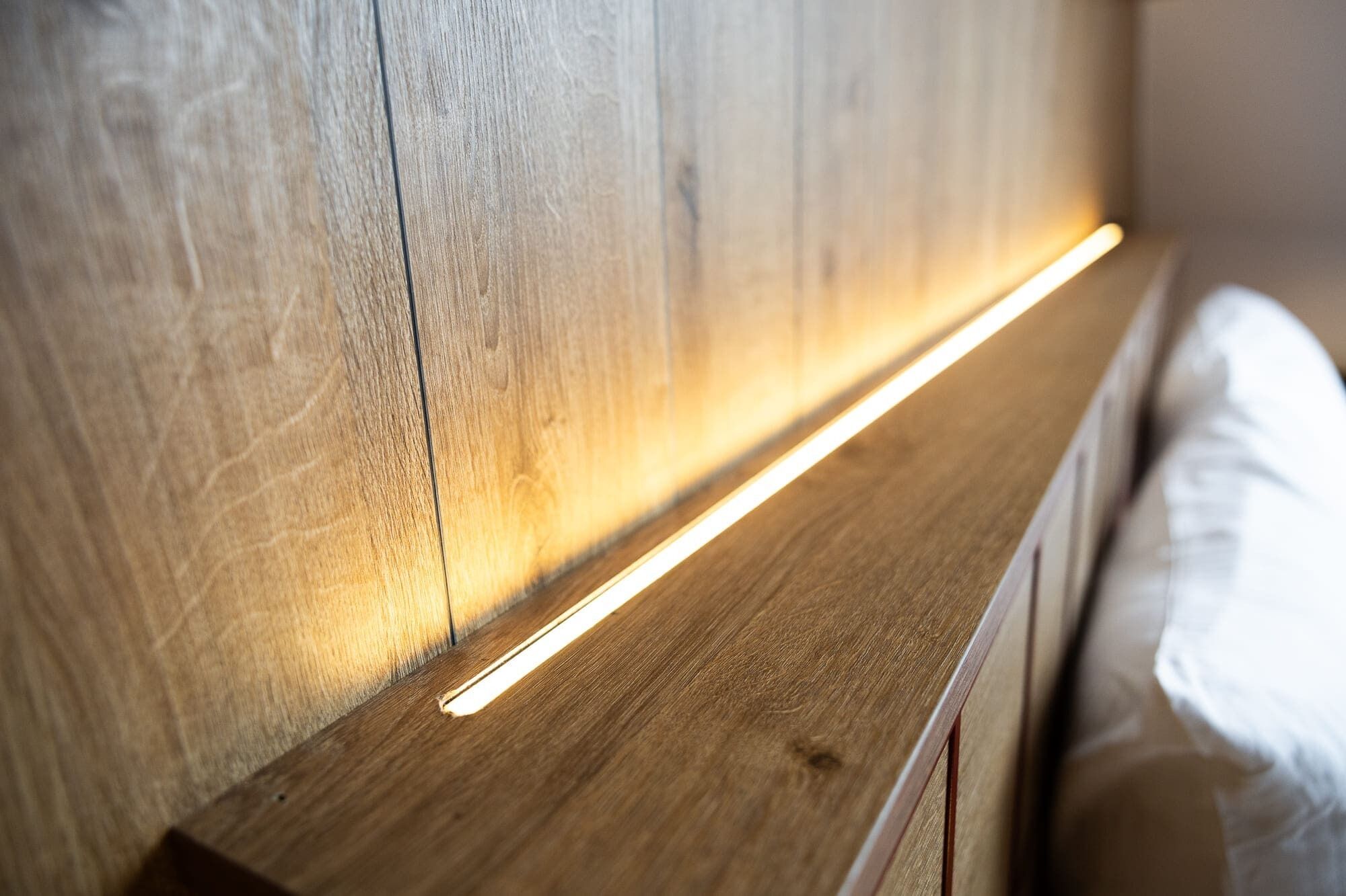 A wooden headboard with a built-in light strip.