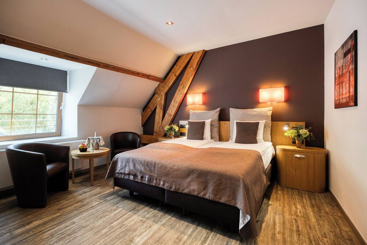 Una habitación de hotel moderna con una cama grande, un escritorio y una silla.