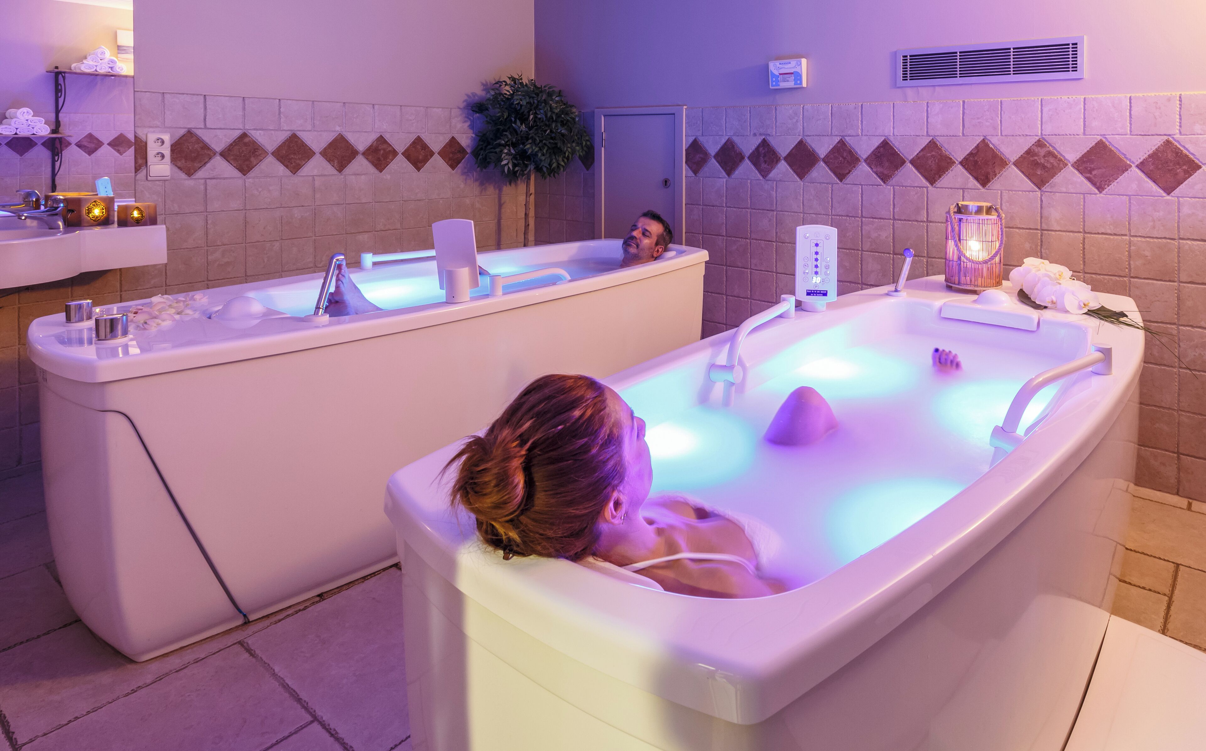 A spa area with two separate tubs, a sink, and a mirror.