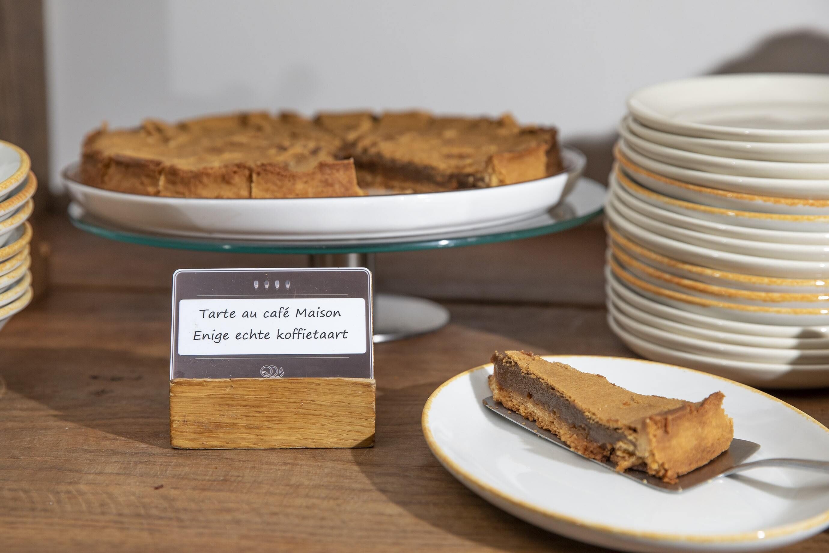 A slice of cake on a plate with a sign in front of it.