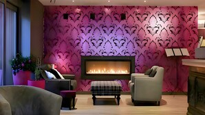 Una sala moderna con chimenea, asientos confortables y un decorativo revestimiento de pared.