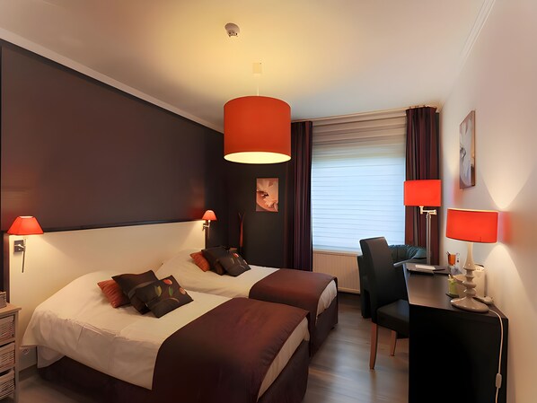 A hotel room with two beds, a desk, and a chair. - Hotel Myrtilles (Vielsalm)