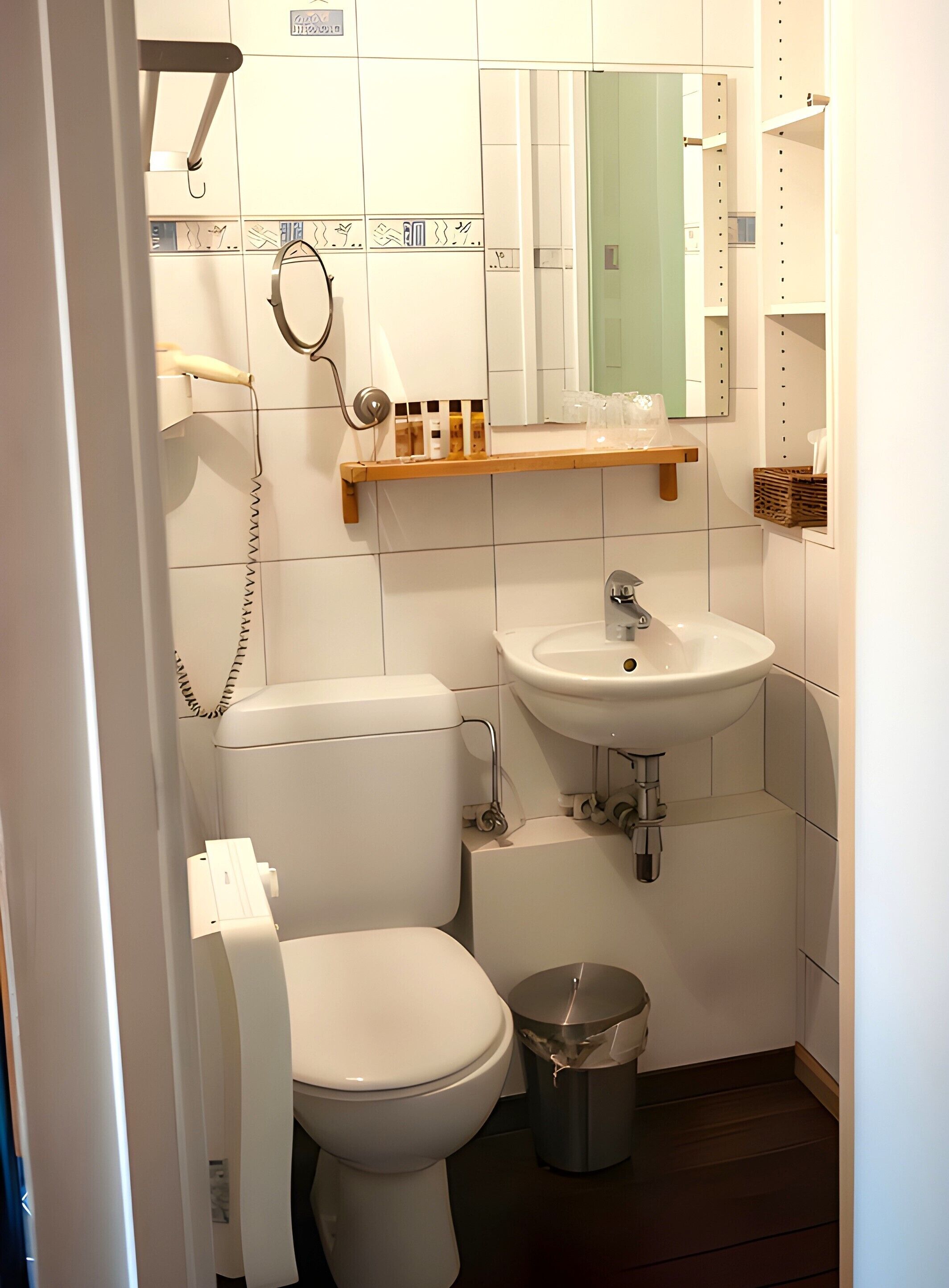 Une petite salle de bain avec des toilettes, un lavabo et une poubelle.