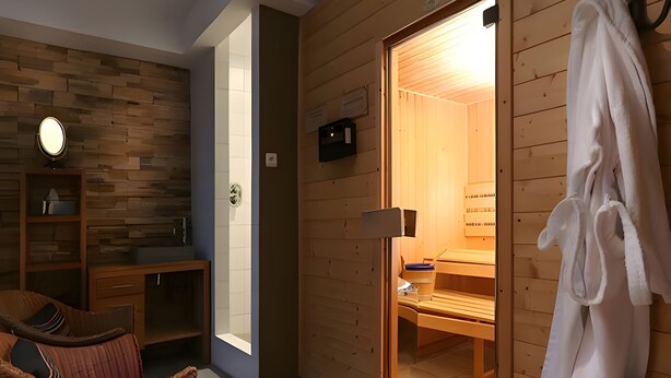 Un sauna con paredes de madera, un banco y un perchero para toallas.