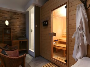 Un sauna con paredes de madera, un banco y un perchero para toallas.
