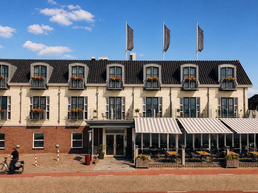 Un hotel con una fila de balcones, una zona de estar al aire libre techada y fachada de ladrillo.