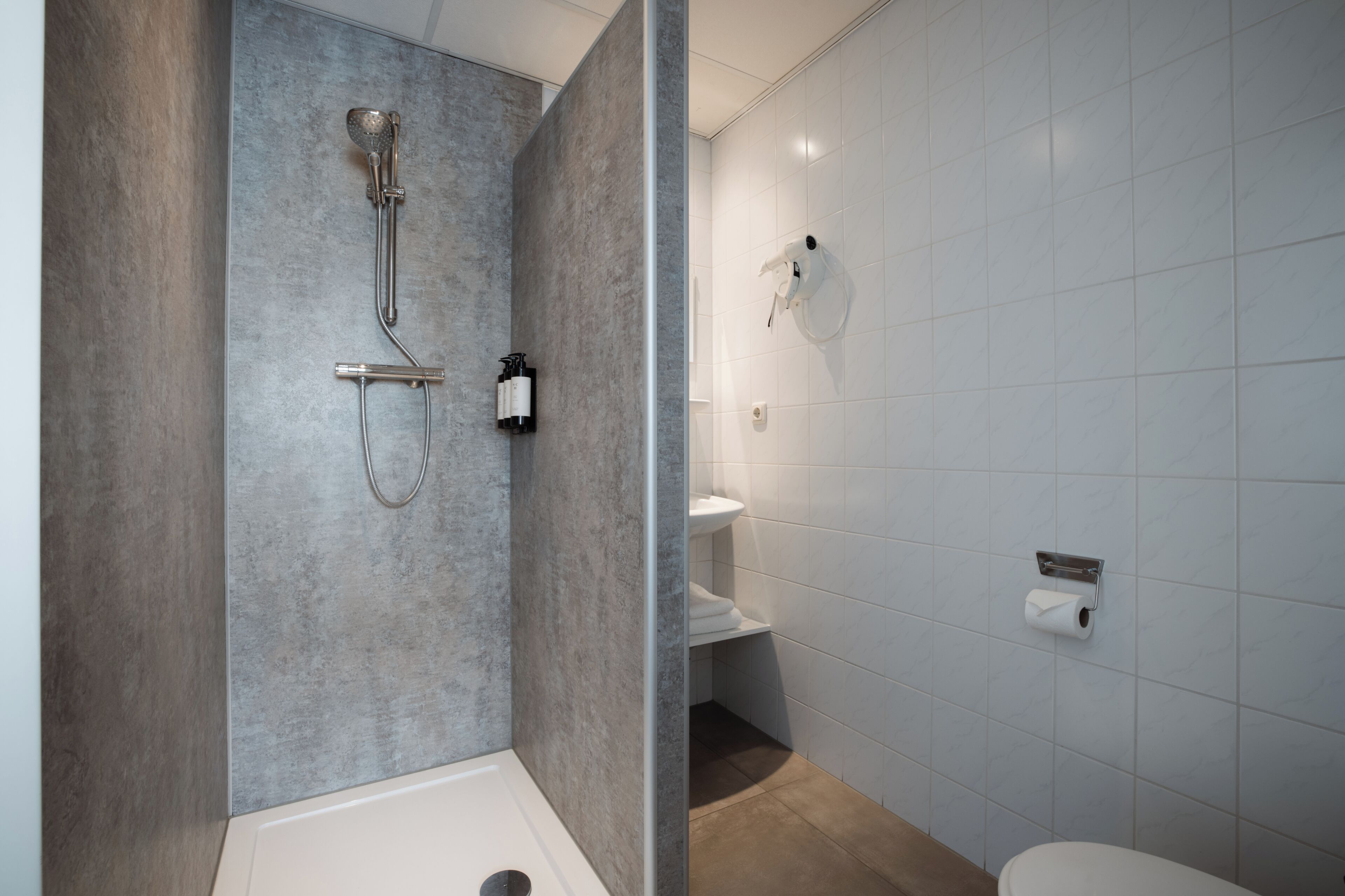 Standaard eenpersoonskamer | Badkamer | Milieuvriendelijke toiletartikelen, een haardroger, handdoeken, zeep