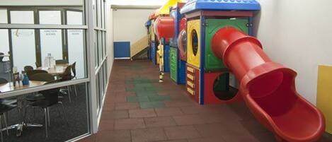 A children's play area with a red slide and various play structures.