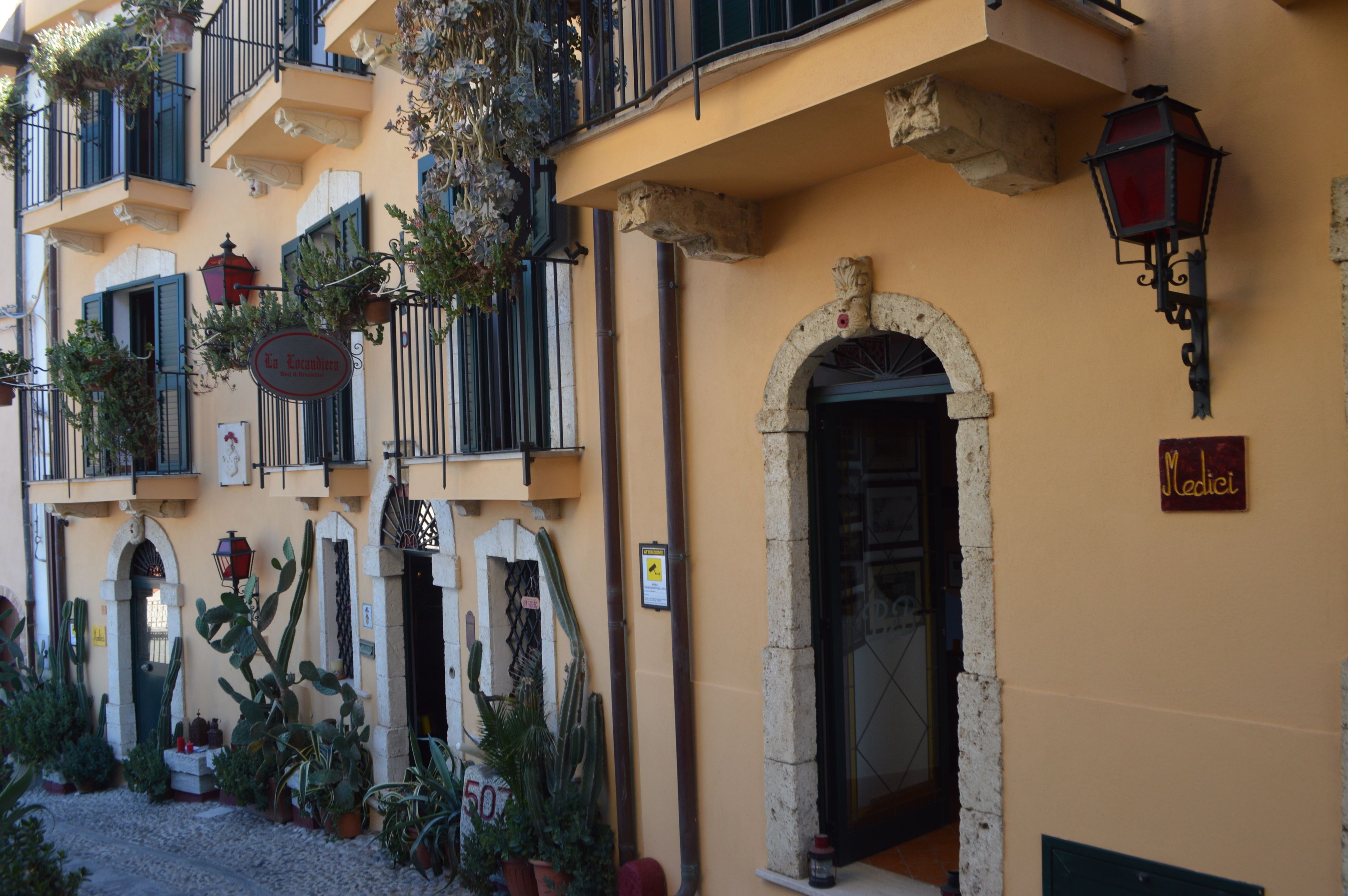 Um edifício com fachada amarela, várias varandas e uma porta com a inscrição 