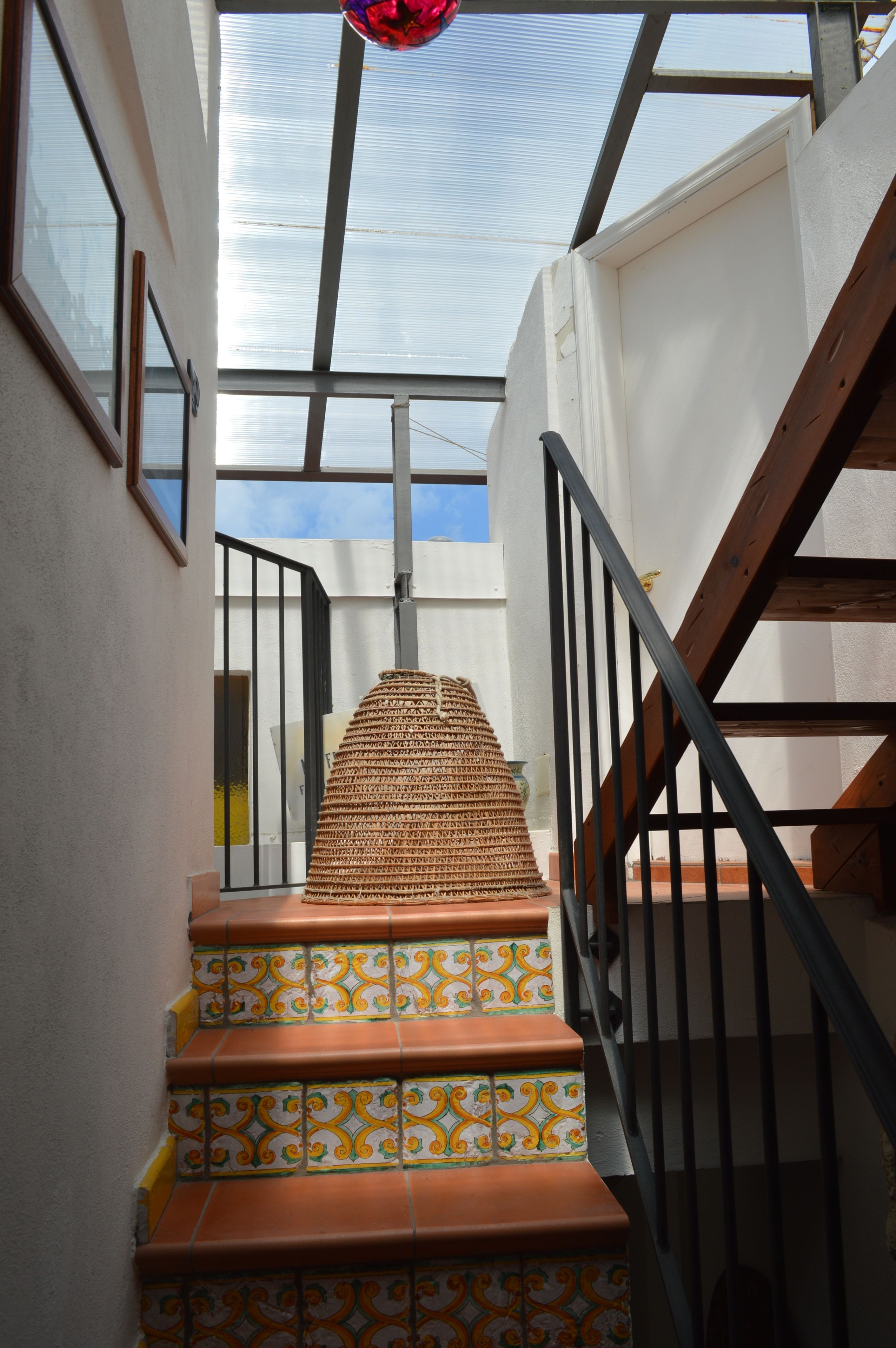 A staircase with patterned tiles leading up to a landing.
