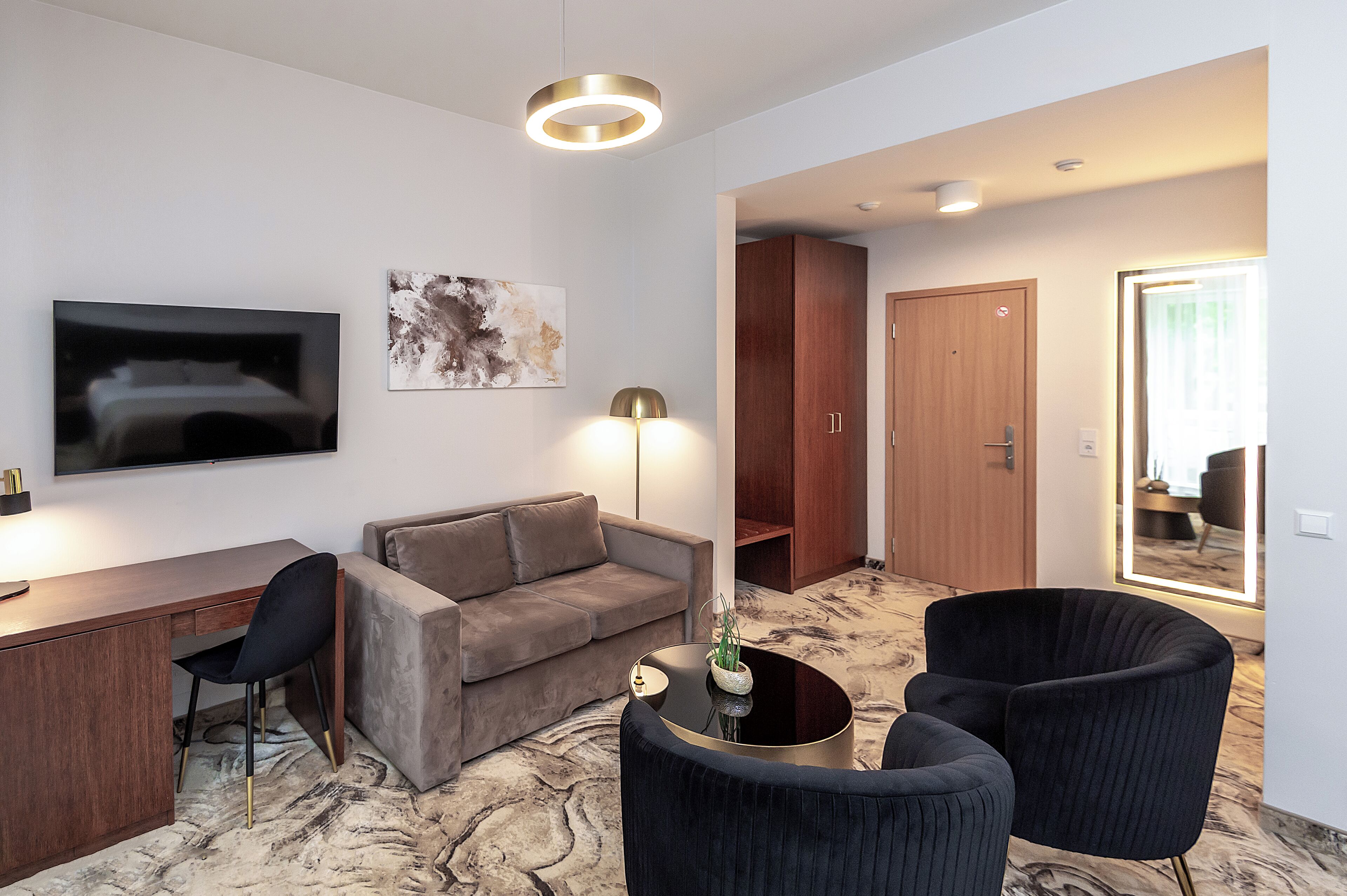A modern living room with a sofa, a desk, a chair, and a coffee table.