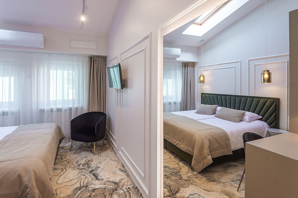 A hotel room with two beds, a flat-screen TV, a desk, and a chair.