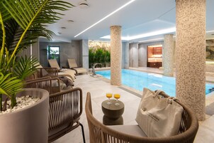Una piscina techada, sillones reclinables de piscina