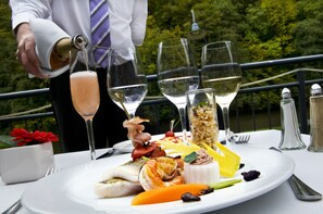 Une table à manger dressée avec une variété de plats, de verres et une bouteille de champagne.