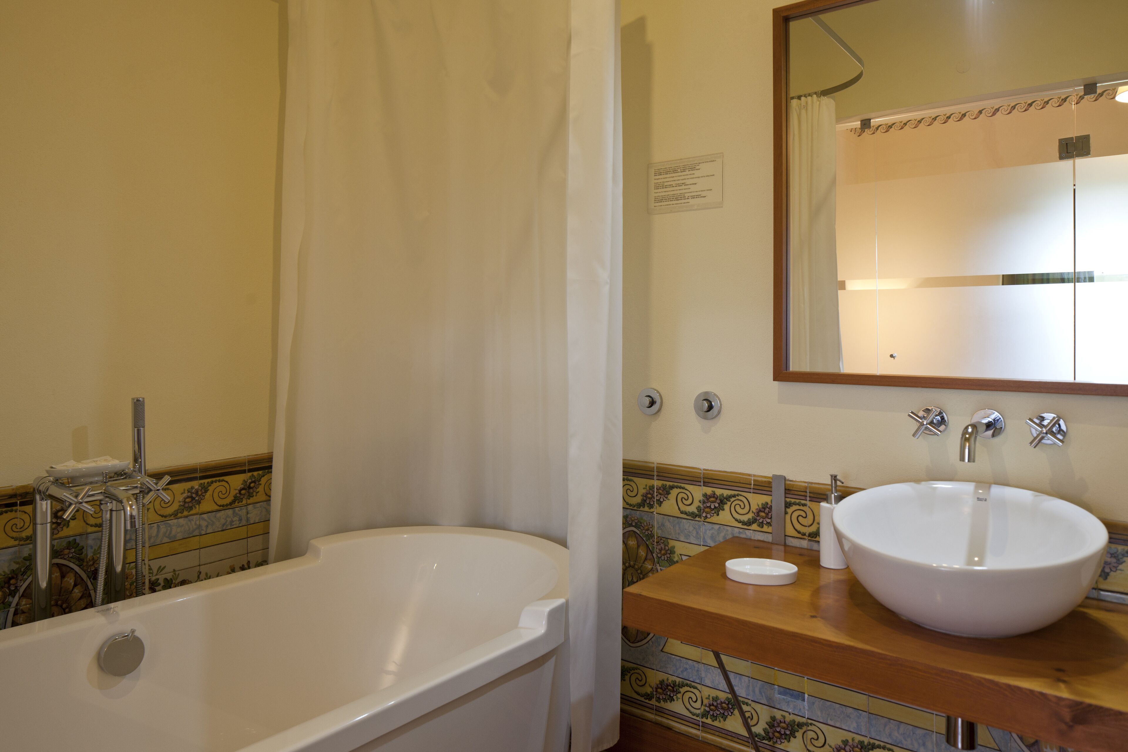 Een badkamer met een bad, een wastafel en een spiegel.