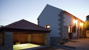 A building with a stone exterior, a tiled roof, and a small outdoor hot tub area. - Solar do Magoito (Sintra)