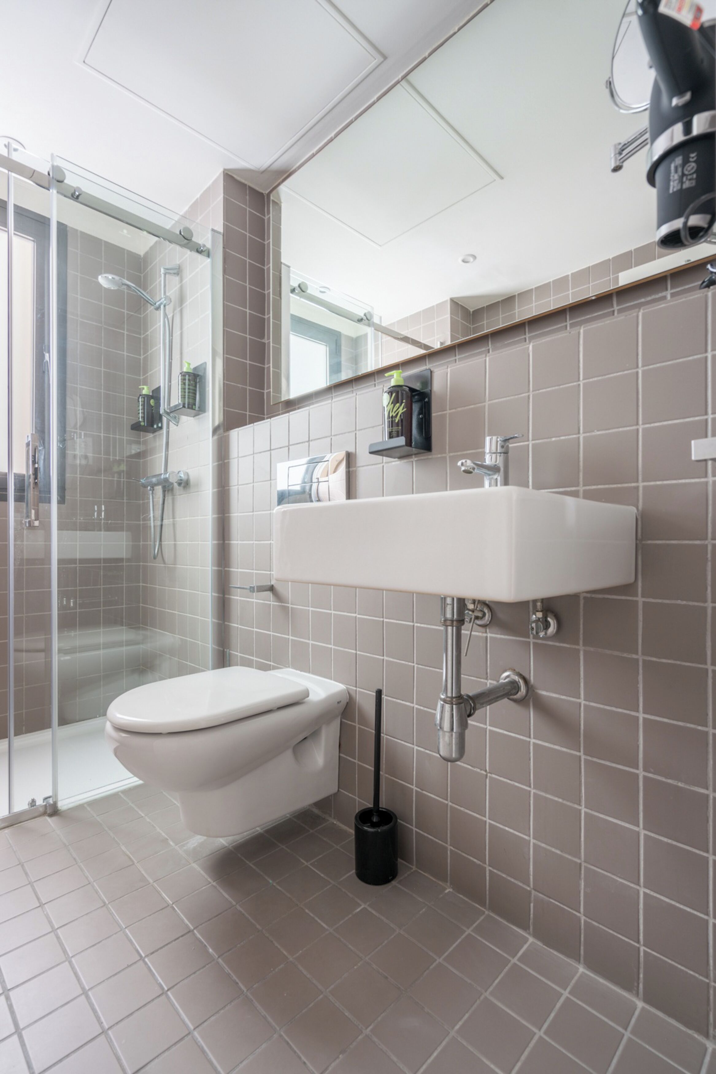 A modern bathroom with a toilet, sink, and shower.