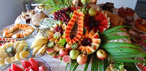 A buffet table with various fruits and pastries.
