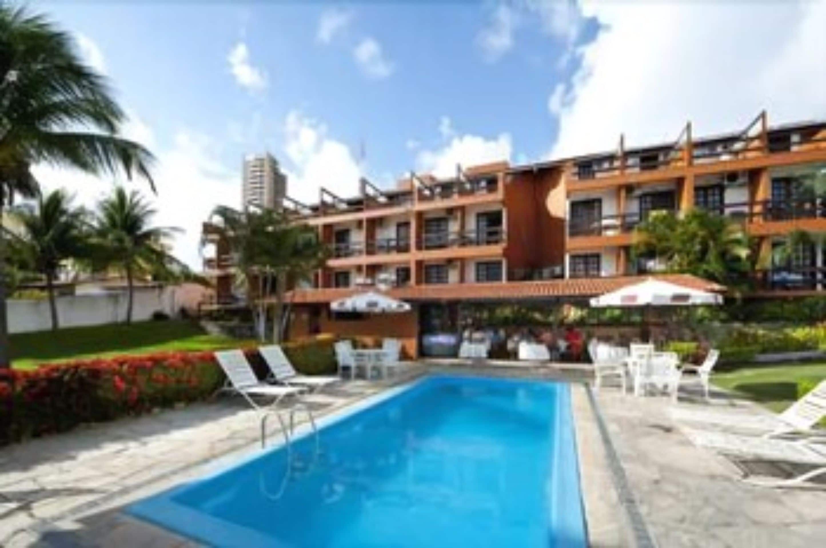 Un hôtel doté d’une piscine, d’un espace extérieur aménagé et d’un bâtiment à plusieurs étages.