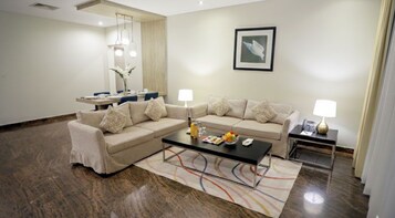 Una sala de estar moderna con un conjunto de sofá, una mesa de centro y un comedor con mesa y sillas.
