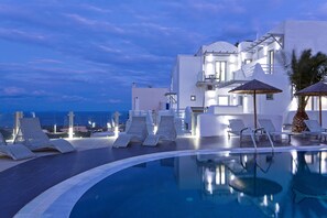 Una piscina al aire libre de temporada, sombrillas