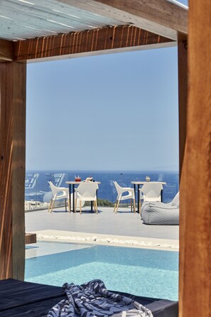 Una piscina al aire libre de temporada, sombrillas, tumbonas