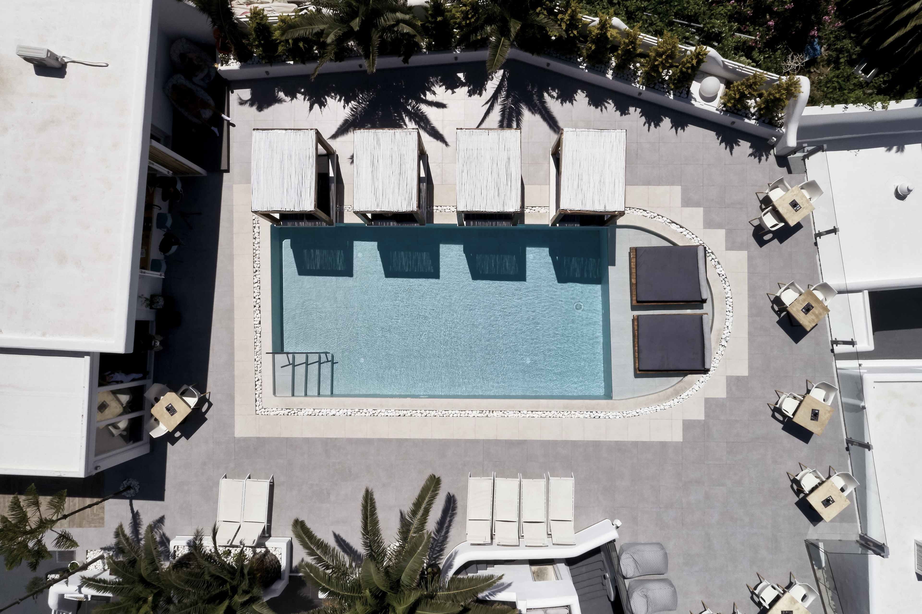An aerial view of a hotel pool area with lounge chairs and a swimming pool.
