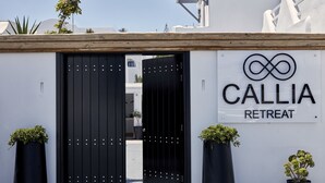 A black gate with a sign reading "CALLIA RETREAT" above it. - Callia Retreat Adults Only (Santorini)
