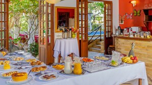 Een terras met een eethoek, een buffet, een koffiehoek en een presentatie van fruit.