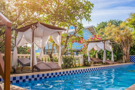 Una piscina al aire libre, sombrillas, sillones reclinables de piscina. Hotel Villa Terra Viva