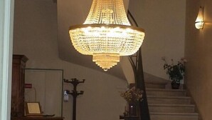 A grand chandelier, a staircase, and a red sofa in a lobby area. - Frederic (Saint-Hilaire-de-Riez)