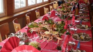 A long dining table set with seafood, including oysters and lobsters, and a red tablecloth. - Frederic (Saint-Hilaire-de-Riez)